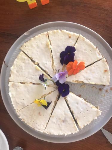 a cake with flowers on top of it on a table at L'Atelier, Confort, Bain à remous et Nature in Parisot-Tarn-et-Garonne
