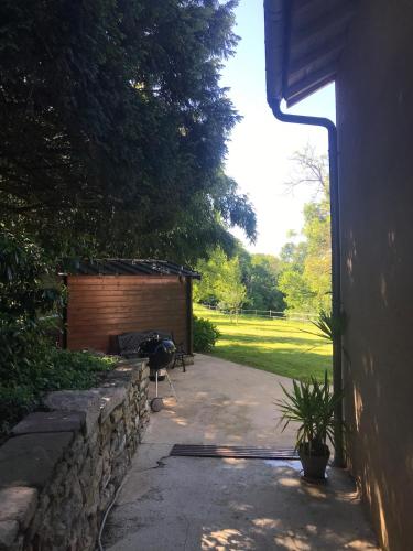 a backyard with a barbecue grill and a building at L'Atelier, Confort, Bain à remous et Nature in Parisot-Tarn-et-Garonne