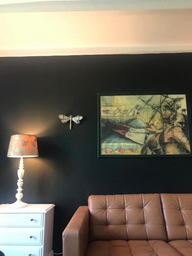 a living room with a couch and a painting on the wall at L'Atelier, Confort, Bain à remous et Nature in Parisot-Tarn-et-Garonne