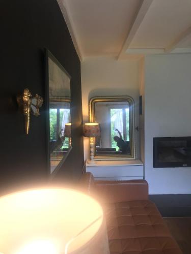 a room with a mirror and a table and a lamp at L'Atelier, Confort, Bain à remous et Nature in Parisot-Tarn-et-Garonne