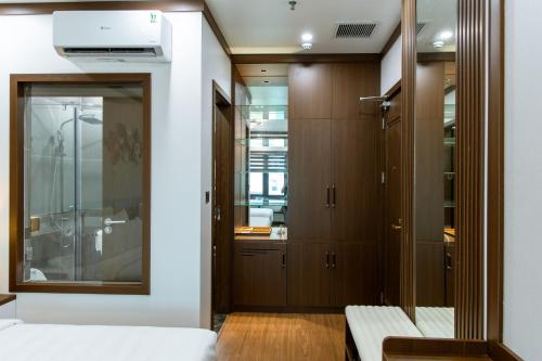 a bedroom with wooden cabinets and a mirror at NEW SUN NAM ĐỊNH hotel in Nam Ðịnh