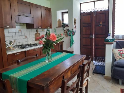 a kitchen with a table with a vase of flowers on it at Sauze d'Oulx ciabot la garitüla with garden - wifi- close to the chairlift in Sauze dʼOulx