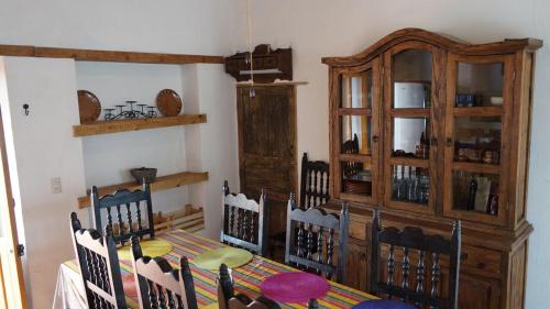 a dining room with a table and chairs and a china cabinet at Casa Orquídea con Alberca en Centro Histórico in Parras de la Fuente