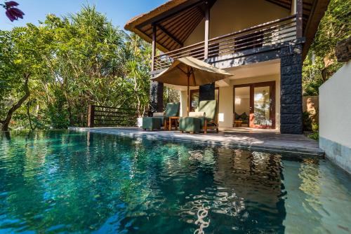 a villa with a swimming pool and a house at Qunci Villas Resort in Senggigi 