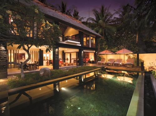 a villa with a swimming pool at night at Qunci Villas Resort in Senggigi 