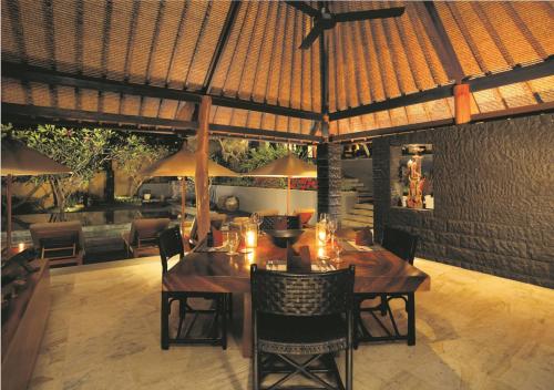 a dining room with a table with chairs and umbrellas at Qunci Villas Resort in Senggigi 