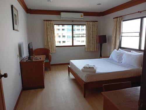 a bedroom with a bed and a television in it at Inn House- SHA Extra Plus in Pattaya Central
