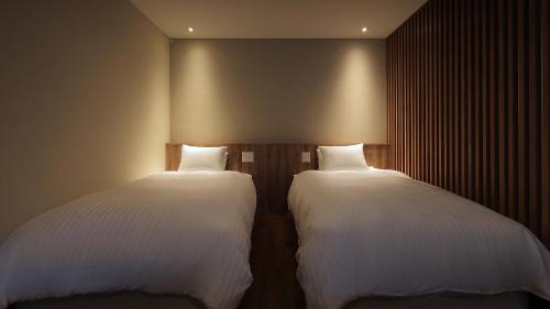 two beds sitting next to each other in a room at Tsuganoki in Nikko