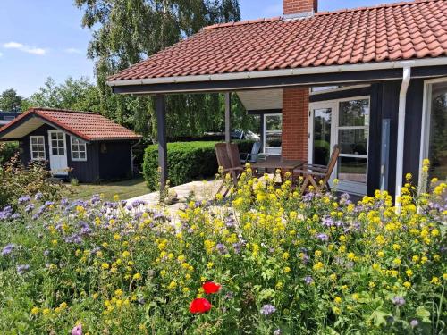 a garden with flowers in front of a house at Cozy Summer House By The Beach And Forest in Haderslev