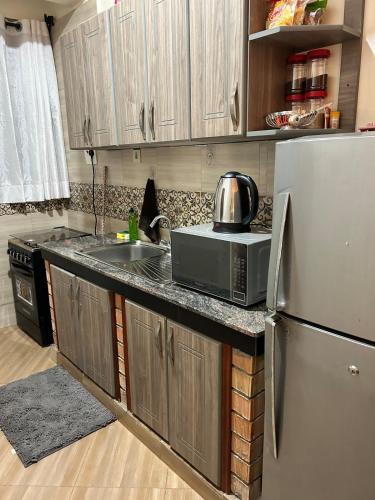 a kitchen with a stainless steel refrigerator and a microwave at Studio room in Kira, Bulindo in Bulindo