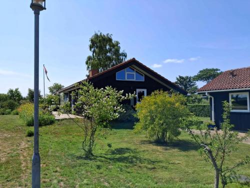 a house with a light pole in front of it at Cozy Summer House By The Beach And Forest in Haderslev