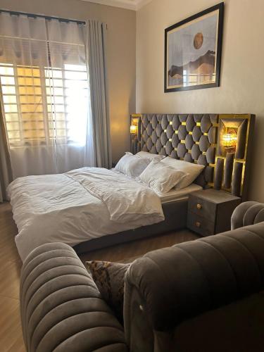 a bedroom with a large bed and a couch at Studio room in Kira, Bulindo in Bulindo