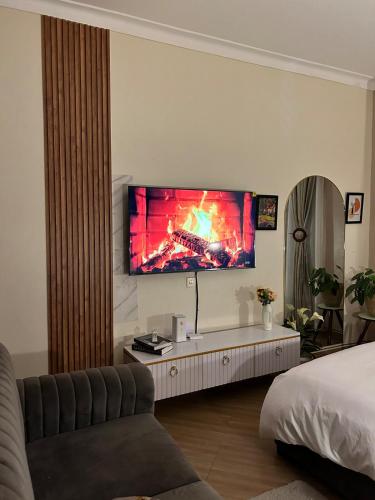 a living room with a tv on the wall at Studio room in Kira, Bulindo in Bulindo