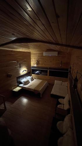 a room with two beds in a wooden room at Dew Hut 