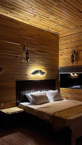 a bedroom with a large bed with wooden walls at Dew Hut 
