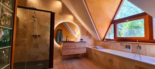 a bathroom with a shower and a sink and a window at L'atelier in La Rochefoulques