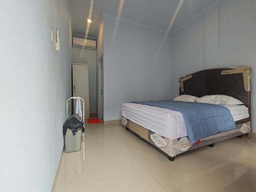 Un dormitorio con una cama en una habitación blanca. en Cherry Homestay, en Kuta Lombok