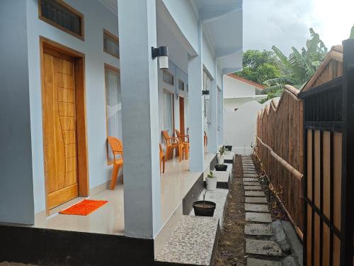 un pasillo de una casa con puerta y sillas en Cherry Homestay, en Kuta Lombok