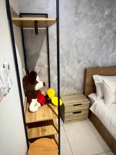 a teddy bear sitting on a shelf in a bedroom at Meritus Suites - 8pax in Perai