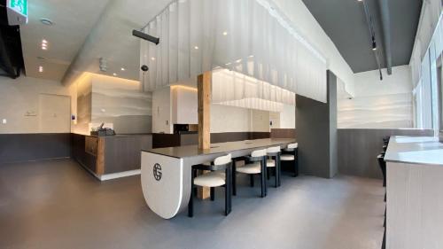a kitchen with a bar with stools and a counter at GOYOO INN & cabins in Seoul