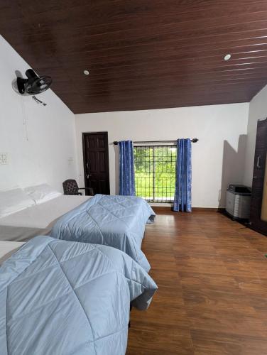 a bedroom with two beds and a window at Rasta Homestay Sakleshpur in Sakleshpur