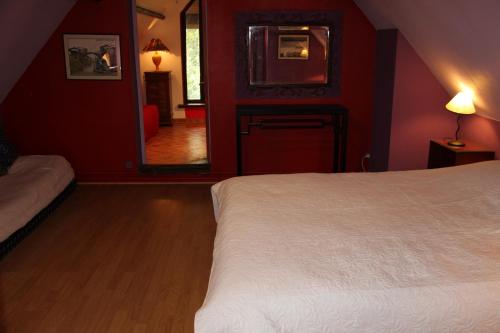 a bedroom with a white bed and a red wall at Pré Le Duc in Broglie