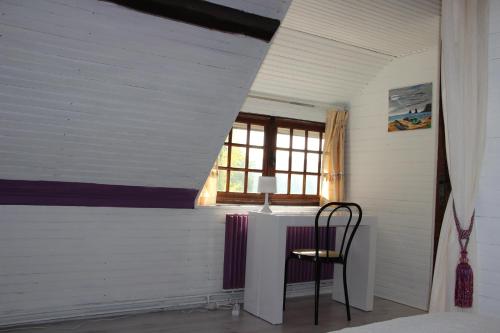 a table and chair in a room with a window at Pré Le Duc in Broglie