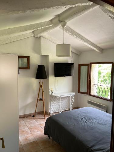 une chambre avec un lit et une télévision au mur dans l'établissement Maison à 20minutes de Nice, à Tourrette-Levens