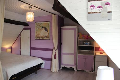 a bedroom with purple and white walls and a bed at Pré Le Duc in Broglie