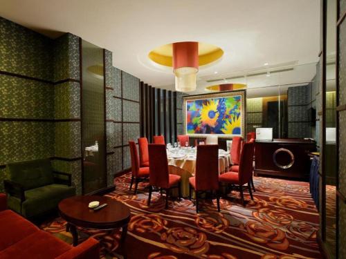 a dining room with a table and red chairs at Putian Depo Hotel in Putian