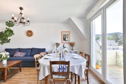 une salle à manger avec une table et un canapé bleu dans l'établissement Lumineux, Terrasse Ensoleille, Vue Panoramique, à Guebwiller