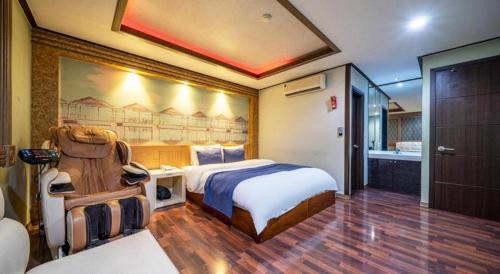 a hotel room with a bed and a bathroom at SKY Hotel in Changwon