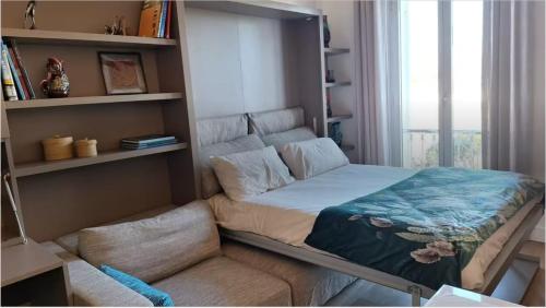 - un lit dans une chambre avec une étagère dans l'établissement Au Cœur du Cap d'Antibes pour 2 personnes, à Antibes