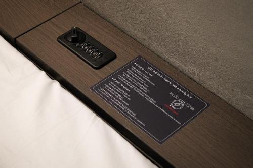 a black tag on the side of a bed at GOYOO INN & cabins in Seoul