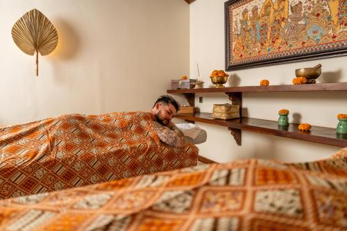 a man laying on a couch in a living room at Mumbul Ubud in Ubud