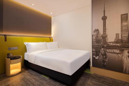 a bedroom with a white bed and a painting at Aerotel Shanghai Pudong Airport Hotel in Shanghai