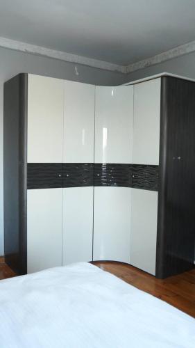a bedroom with a bed and a black and white cabinet at Hostelhome in Türkistan