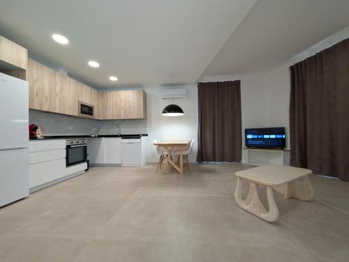 a large white kitchen with a table and a bench at Ca l'Emília, hasta 6 pers, Monistrol de Montserrat in Monistrol