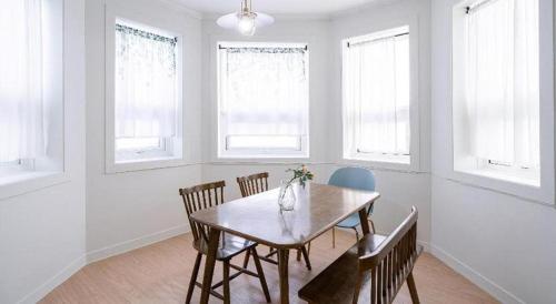 a dining room with a table and chairs and windows at Gallery Pension in Taean