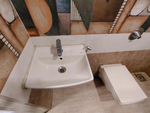 a bathroom with a sink and a toilet at Hotel Harmony heights in Pune