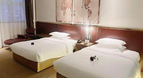 a hotel room with two beds with flowers on them at James Joyce Coffetel Beijing Yizhuang Rongjing East Street Subway Station in Beijing