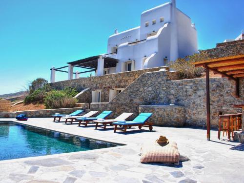 Agios Sostis MykonosにあるGorgeous Villa in Mykonos with Private Poolのスイミングプールのそばのラウンジチェアのグループ