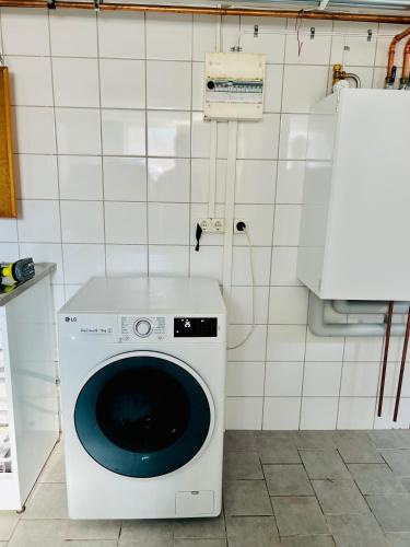 ルンドにあるRoom in Landskronaのタイル張りの壁の客室で、洗濯機が備わります。