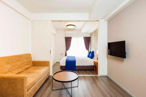 a hotel room with a bed and a couch at FDS Plaisir in Osaka