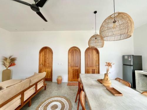 a living room with a table and wooden doors at VILLA LULU 1- 2 bedrooms villa - private pool in Kuta Lombok