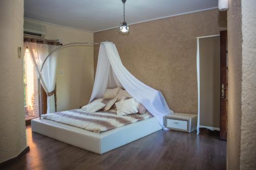 a bedroom with a bed with a mosquito net at Hotel Livia in Ksamil