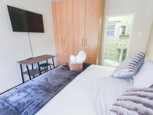 a bedroom with a bed with a television and a table at Hippo's Rest in Ellisras