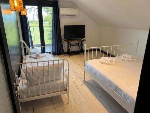 a bedroom with two beds and a flat screen tv at Daskalis House # Даскаловата Къща in Alexandroupoli