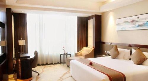 a bedroom with a large white bed in a room at Weida Hotel Jinhua in Jinhua