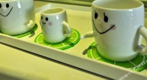 two cups with faces on them sitting on a tray at Huangshan International Hotel in Huangshan